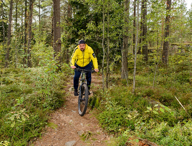 Harri Kiema pyöräilee maastopyörällä metsäpolulla.